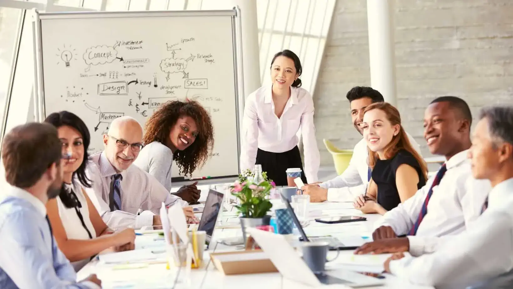 A multicultural group of professionals engaged in a business meeting around a large conference table.