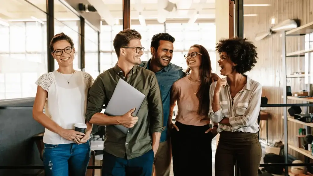 Diverse group of young professionals smiling and collaborating in a modern office – successful team building concept.