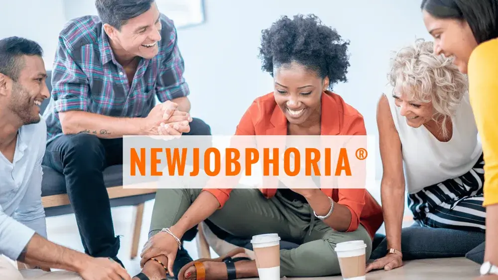 A diverse group of professionals engaged in a discussion, with coffee cups on the floor and "NEWJOBPHORIA" prominently displayed, symbolizing teamwork and excitement.