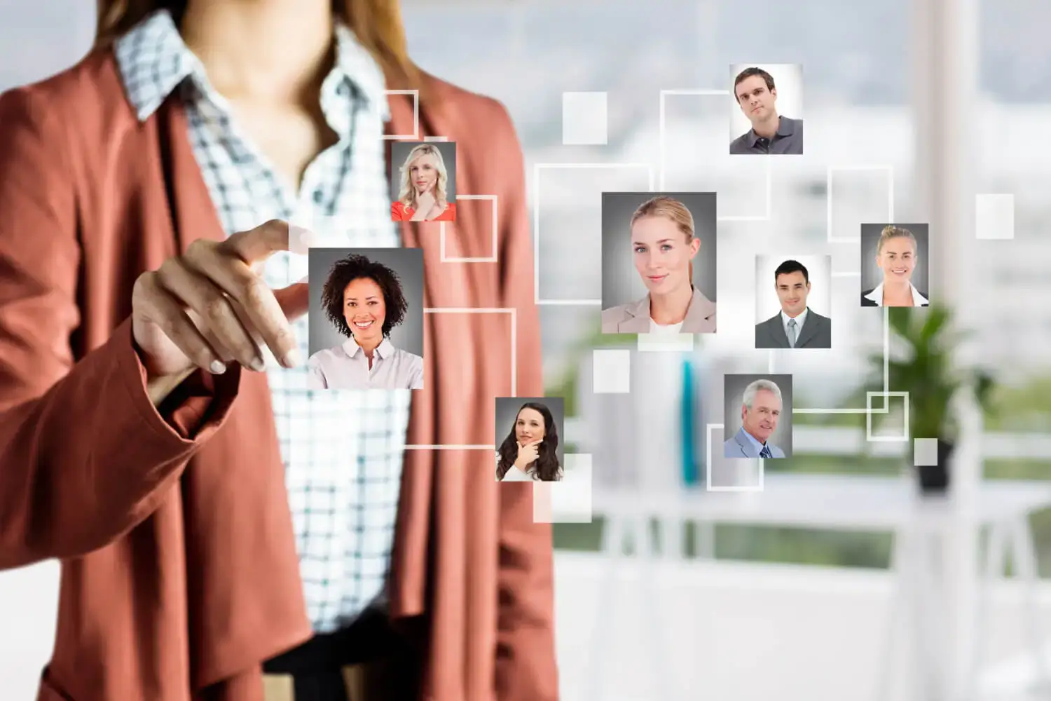 A woman in business attire interacts with a digital interface displaying a network of diverse professional headshots, representing a virtual staffing or recruitment solution.