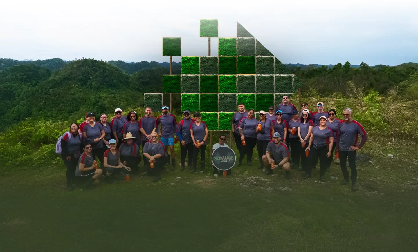 A diverse team poses in front of a vibrant green field, reflecting SPECTRAFORCE's commitment to community and sustainability.