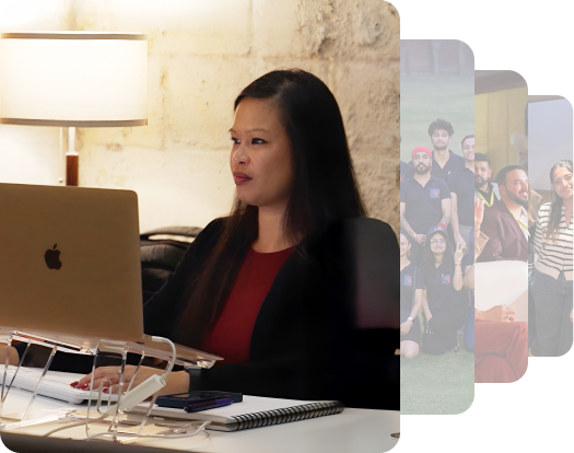 A person seated at a desk with a laptop, a lamp, and a notebook, focused on work with various blurred background images.