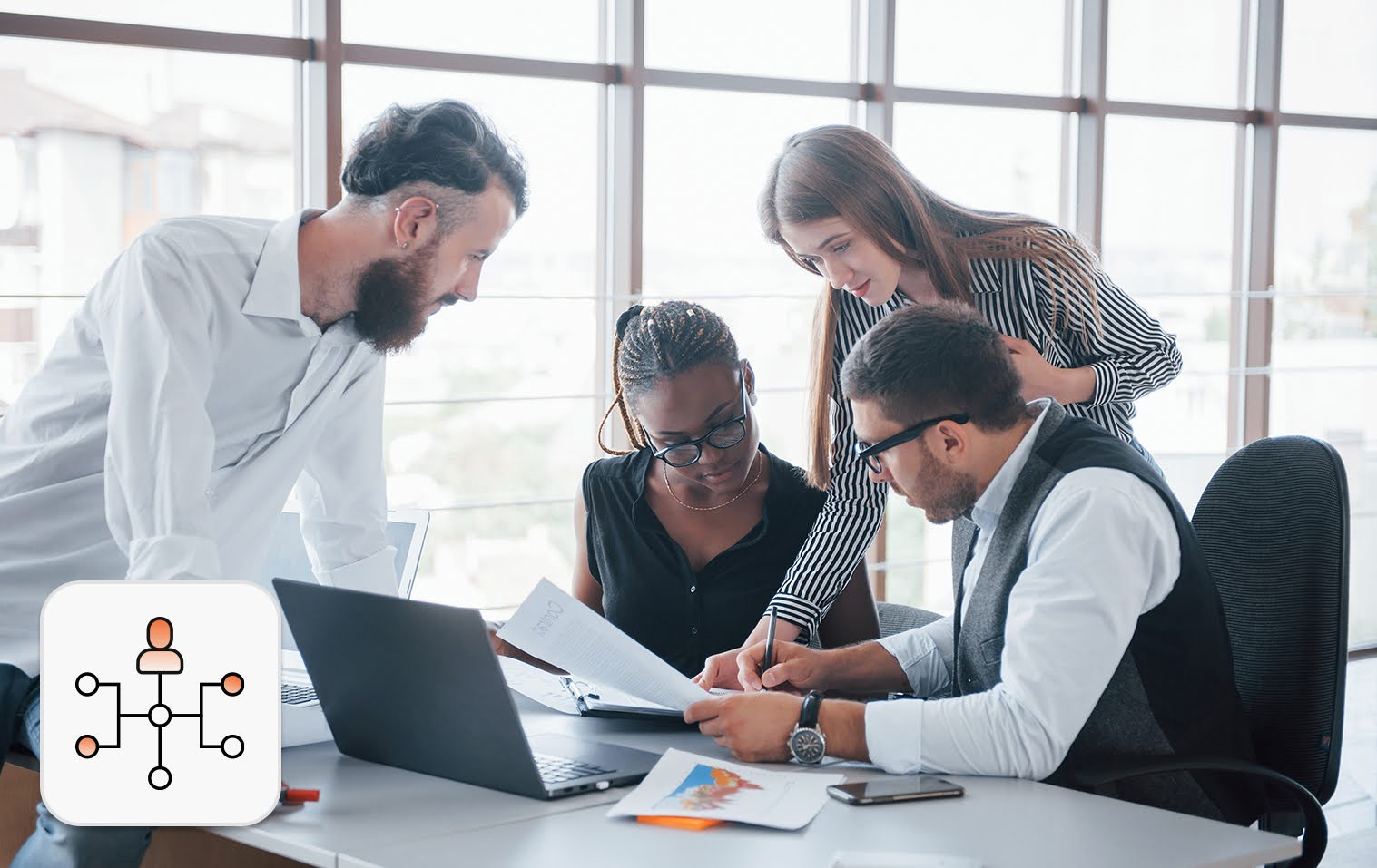 Four employees on a table, collaborating on a project