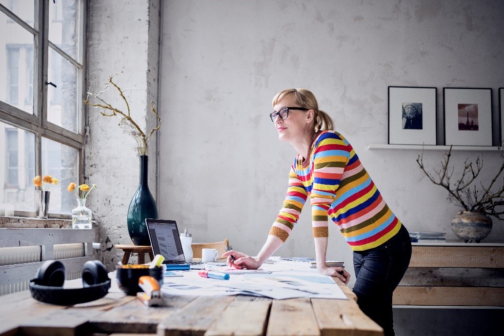 A girl with glasses standing in ergonomic work from home station
