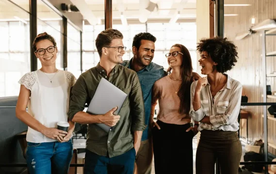 Diverse group of young professionals smiling and collaborating in a modern office – successful team building concept.