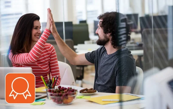Colleagues doing a high five, practicing allyship in the workplace