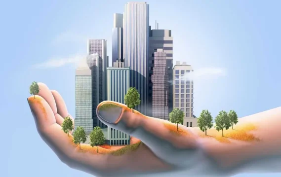 8-Sustainable-Practicies-header A digital hand holds a miniature city with skyscrapers and trees under a blue sky.
