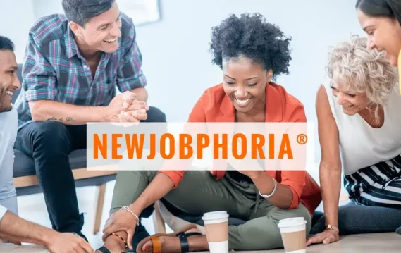 A diverse group of professionals engaged in a discussion, with coffee cups on the floor and "NEWJOBPHORIA" prominently displayed, symbolizing teamwork and excitement.
