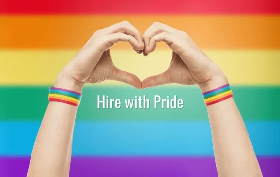 Hands forming a heart shape against a rainbow background, wearing pride wristbands, with the text “Hire with Pride.”
