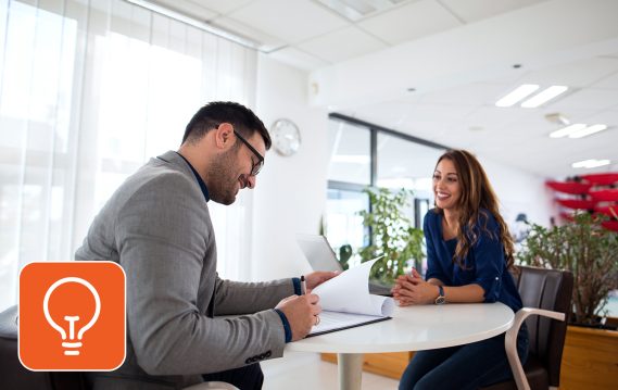 Two people discussing work in an office setting