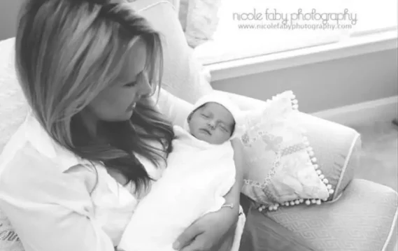 Mother holding newborn baby wrapped in blanket, showcasing love, bonding, and family moments at home.