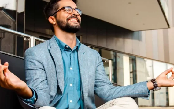 Working professional practicing mindfulness outdoors with a joyful expression.