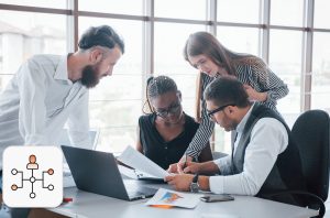 Four employees on a table, collaborating on a project