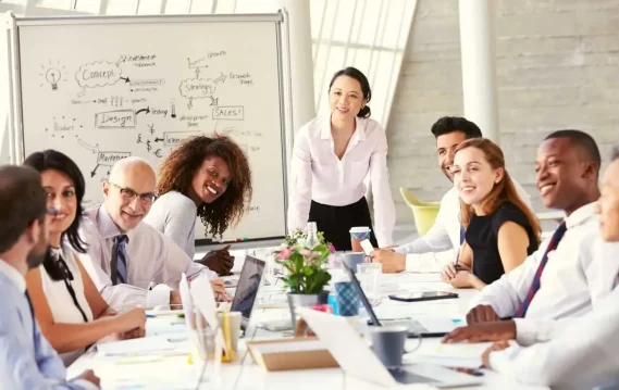 A multicultural group of professionals engaged in a business meeting around a large conference table.